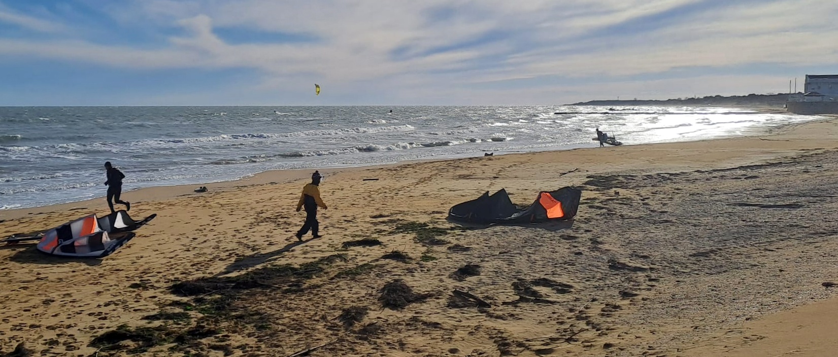 Bora, gelide raffiche, sole, frangenti, ... tutti in mare con tavole e vele a Lignano Sabbiadoro