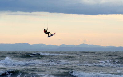 Natale in Mare a Lignano coloratissime tavole e vele tra raffiche di Bora, onde, frangenti.